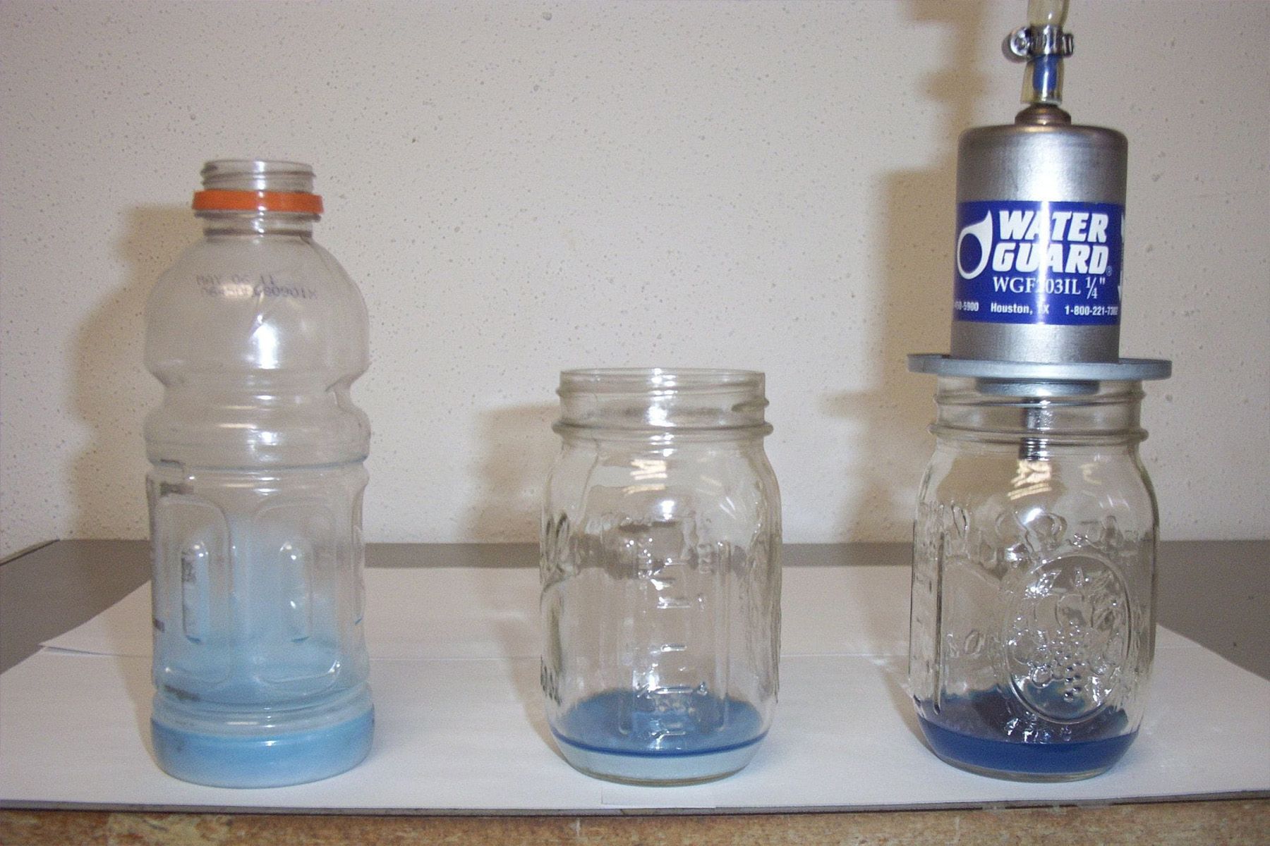 Three jars and a bottle that says water guard on it