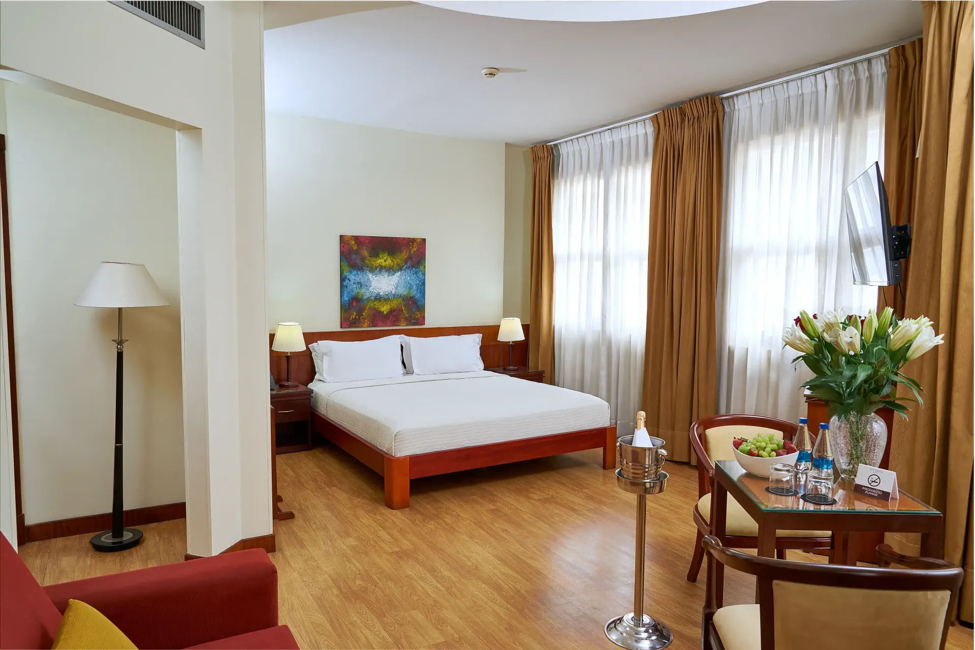 A hotel room with a large bed and a table and chairs
