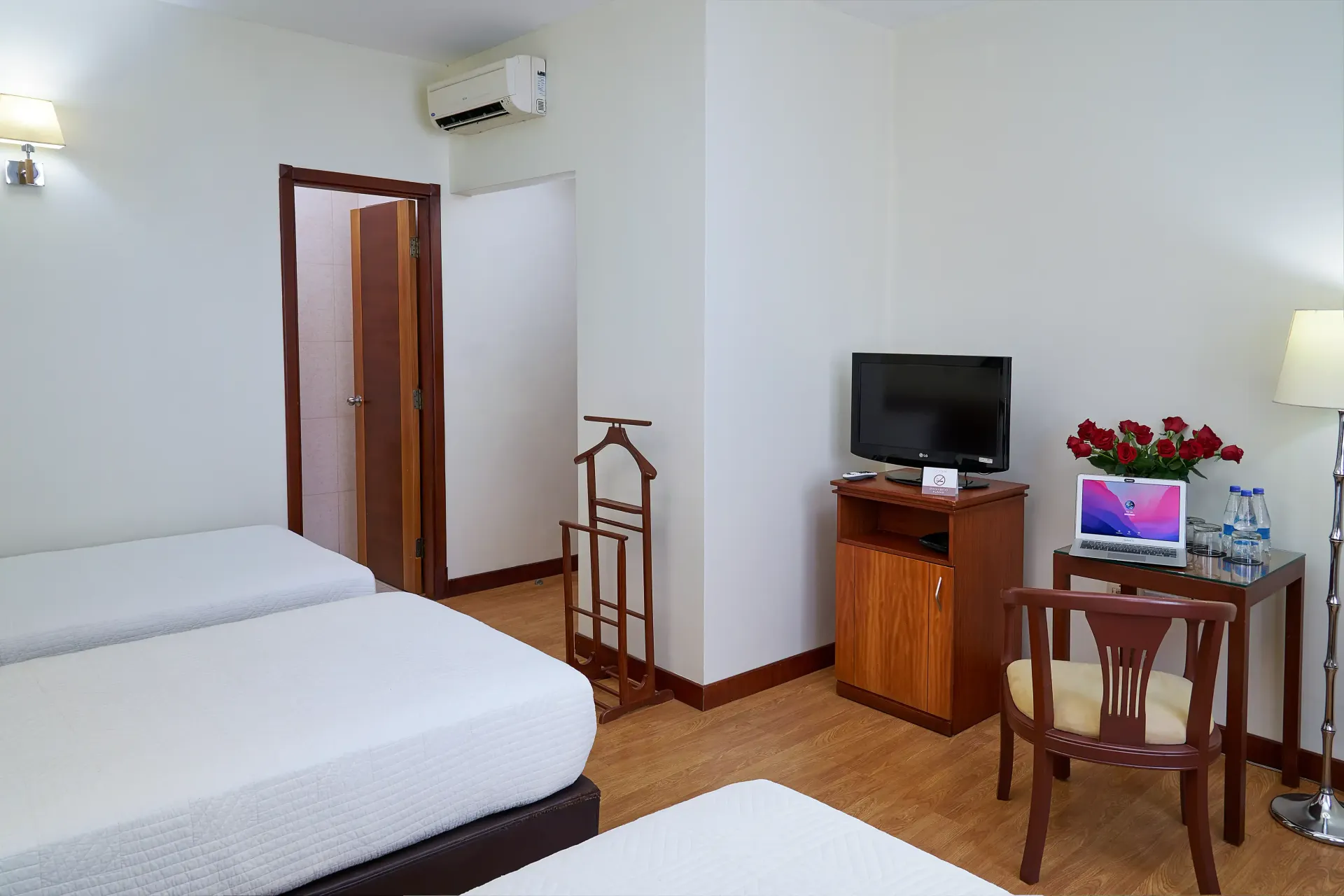 A hotel room with two beds , a desk and a television.
