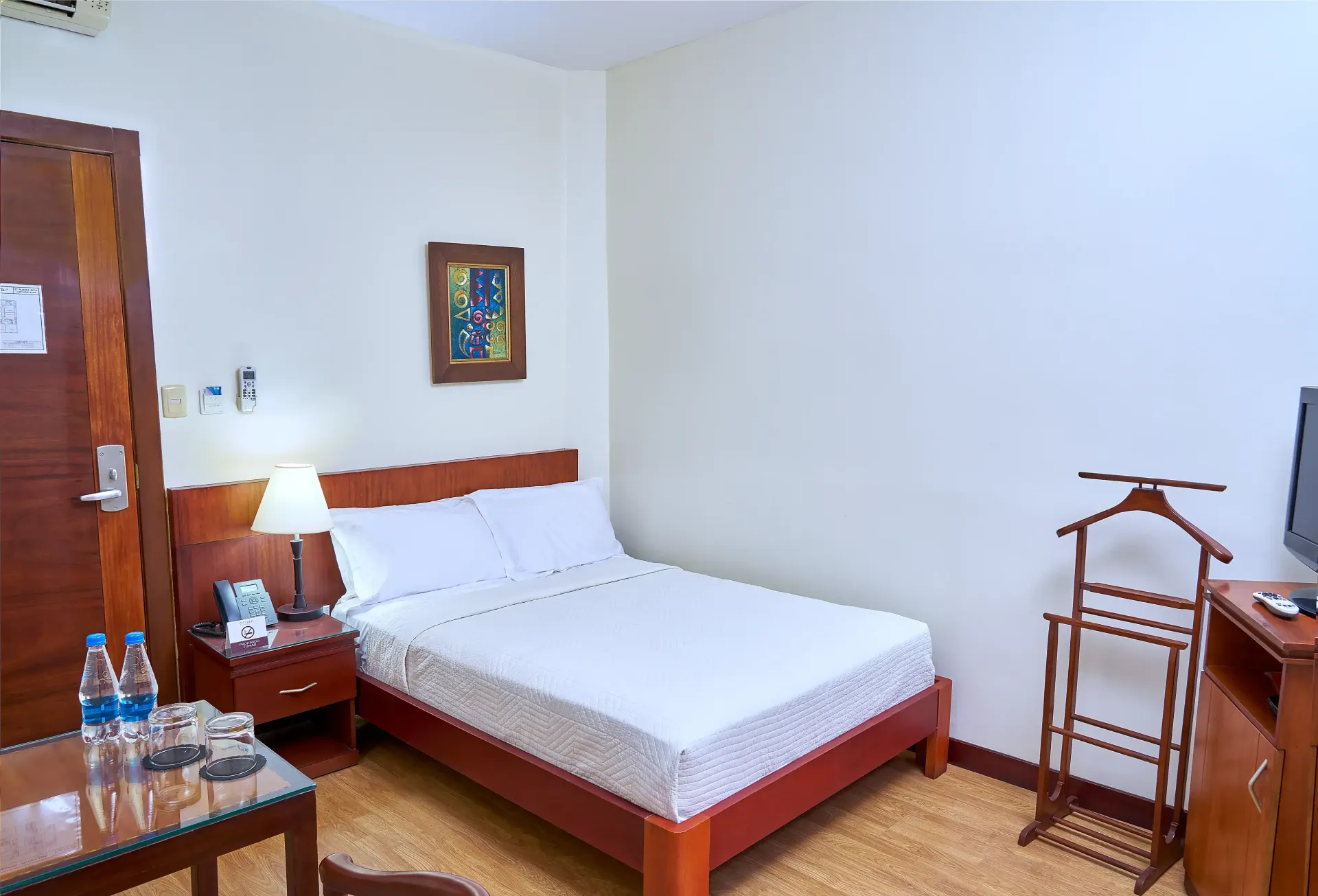 A hotel room with a king size bed and a television