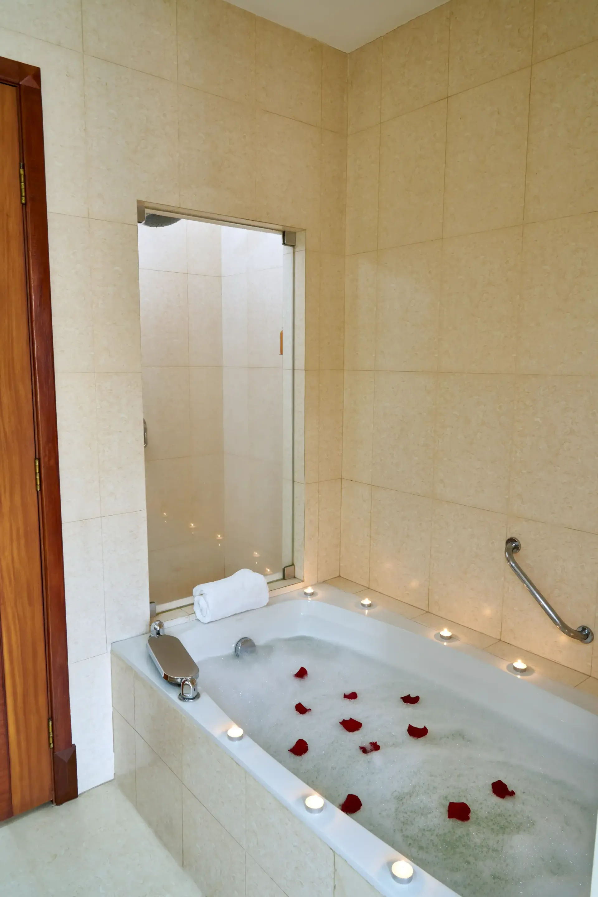 A bathroom with a bathtub filled with water and candles