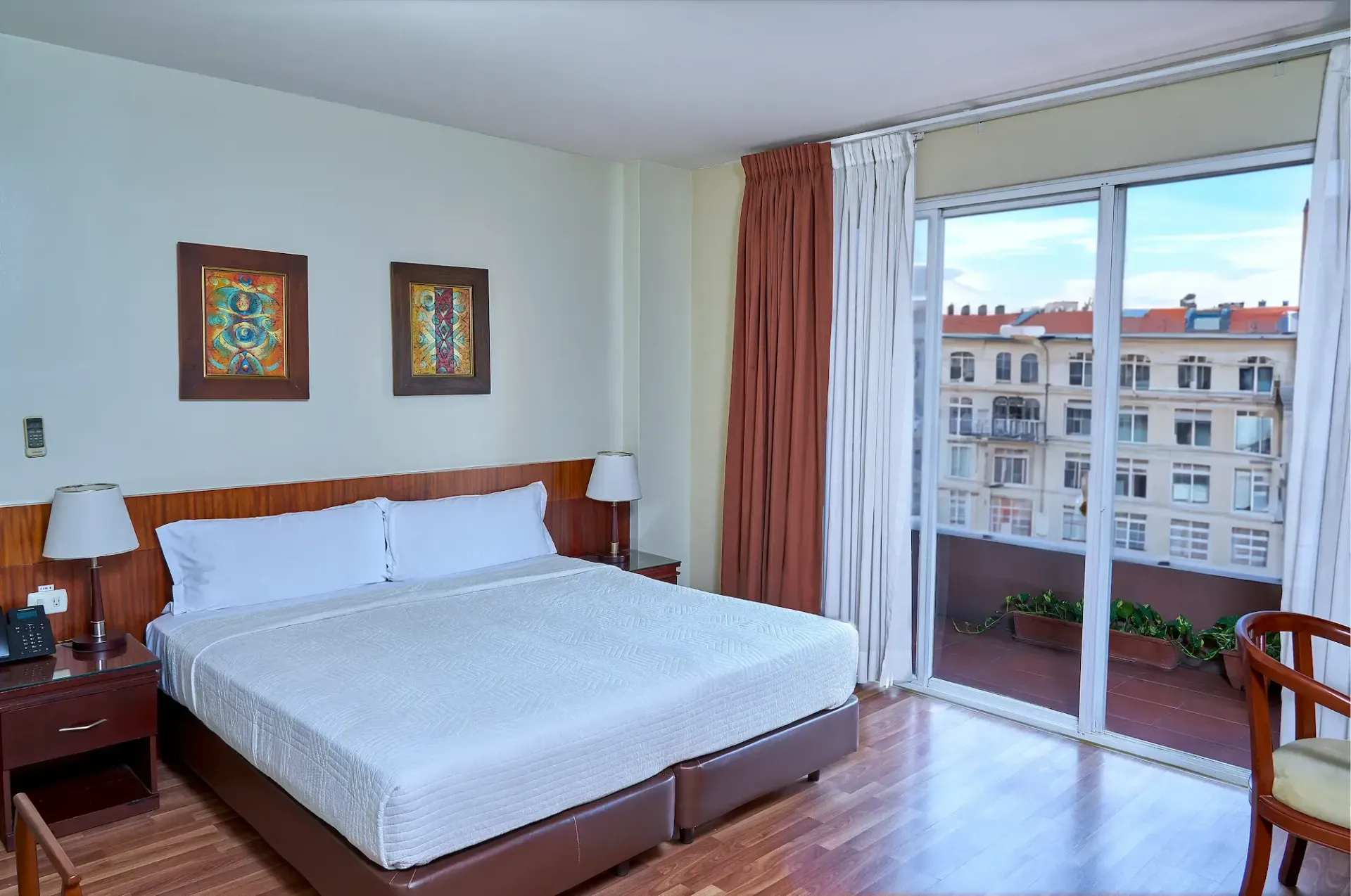 A hotel room with a large bed and sliding glass doors