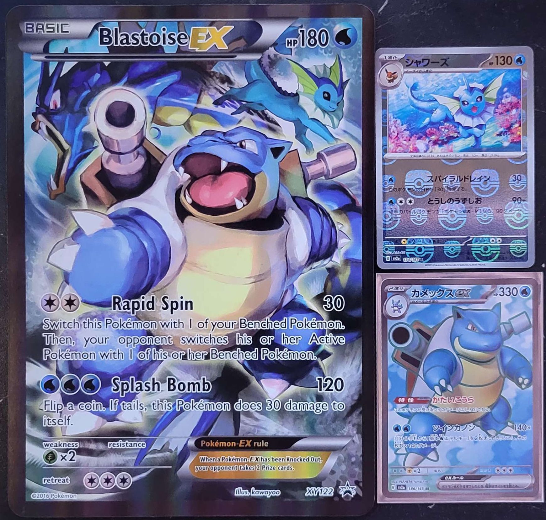 a jumbo pokemon sized pokemon card next to two standard sized pokemon carrds
