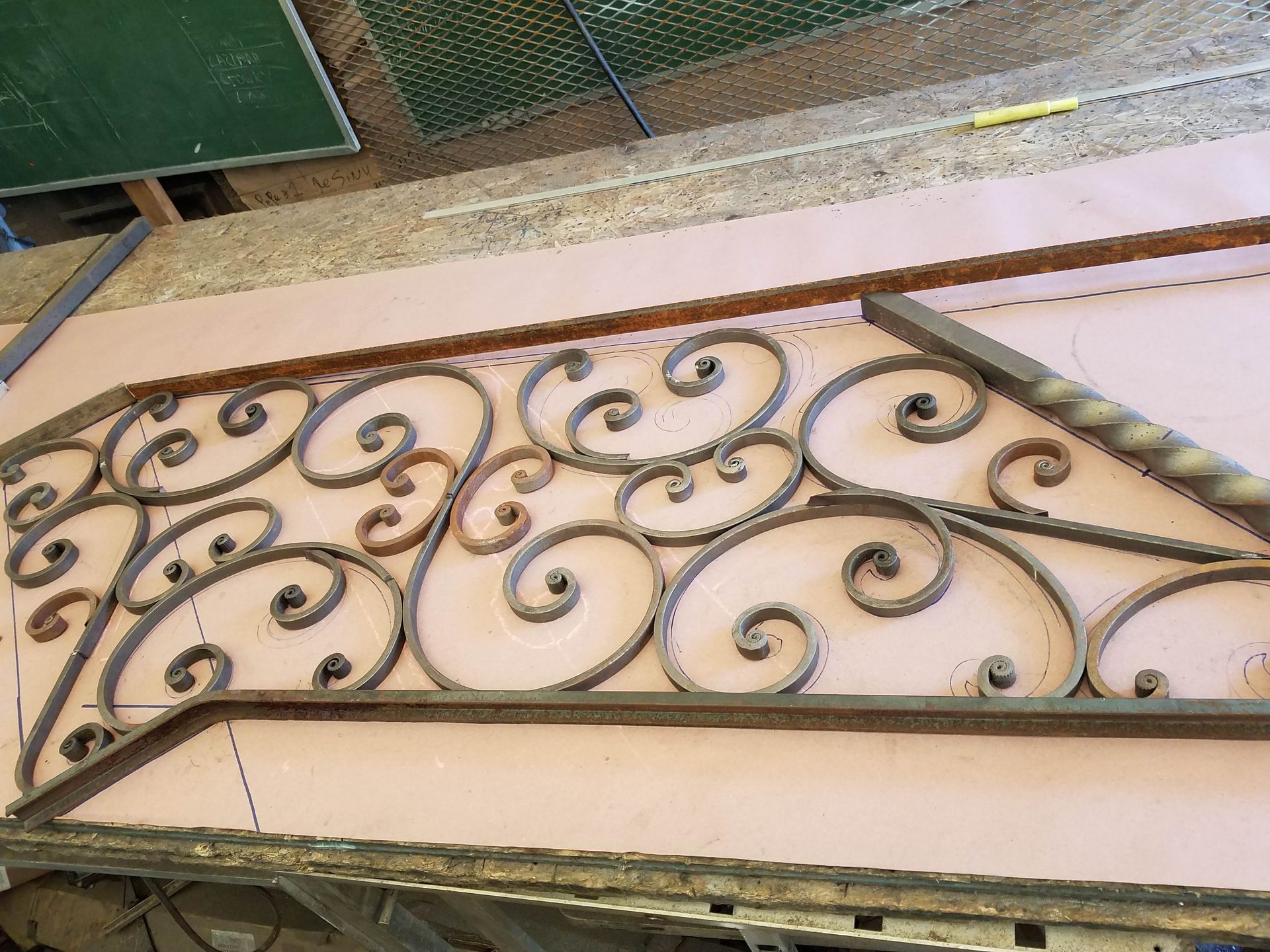 Ornate brown wrought-iron railing with scrollwork above a tiled stair landing