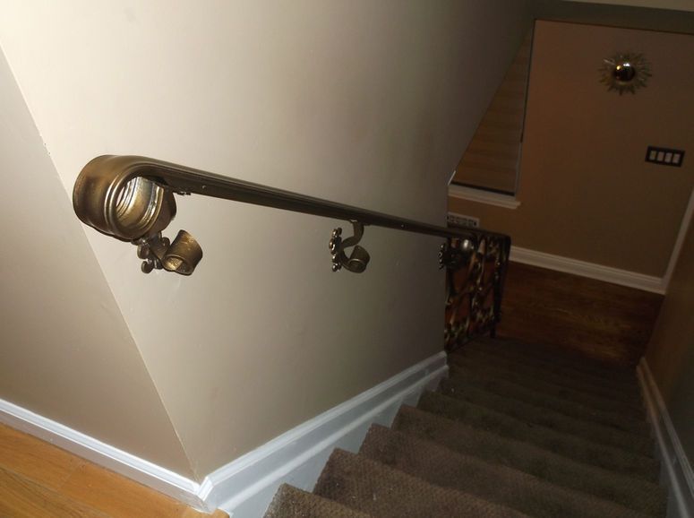 Stairwell with carpeted steps and dark handrails, viewed from the top landing.