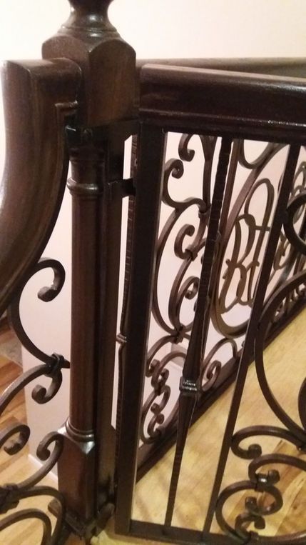 Ornate dark wood and wrought iron stair railing with decorative scrollwork
