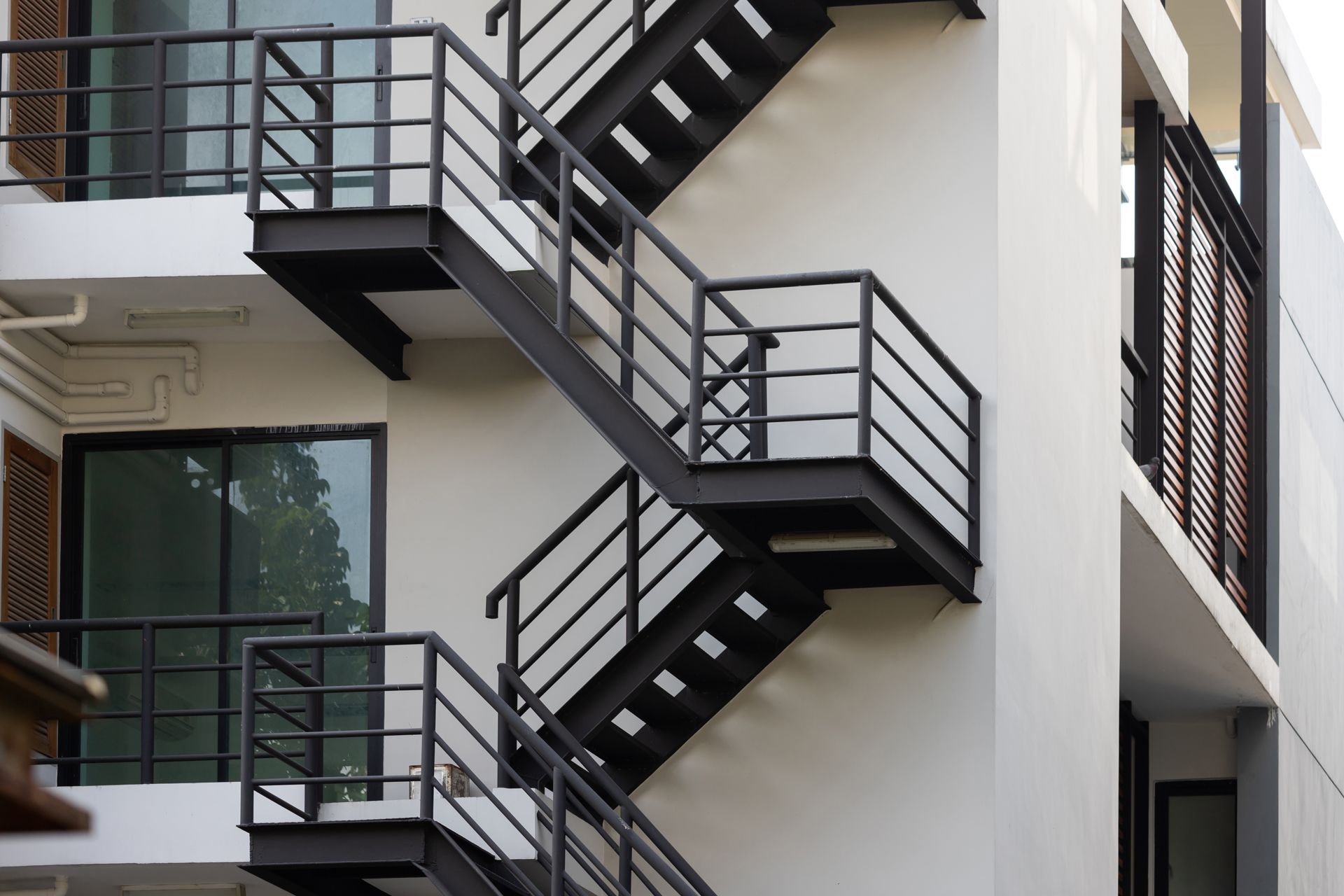 Black metal exterior fire escapes on a modern white building