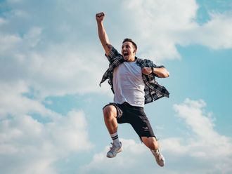 A man is jumping in the air with his arms in the air.