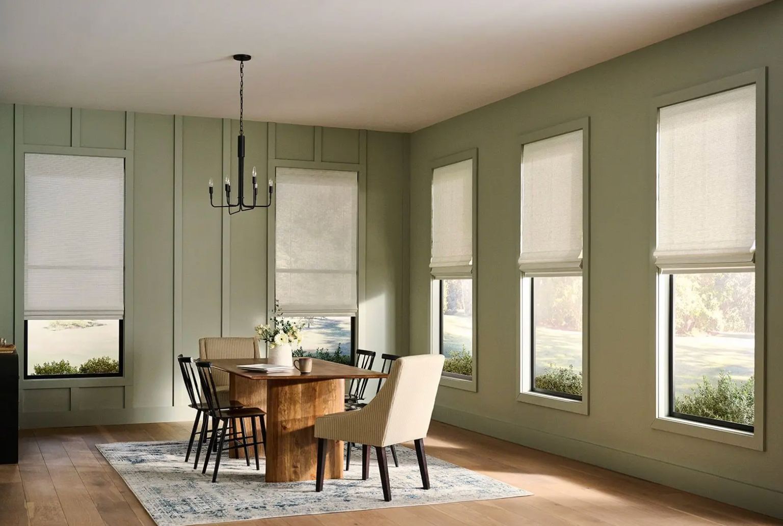 Alta® window shades covering multiple windows in a modern, green dining room.