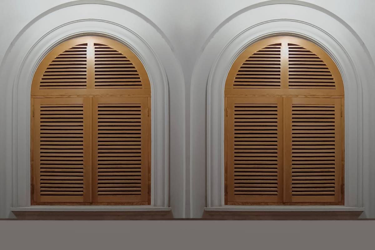 A pair of arched window blinds in a room near Manchester, NH