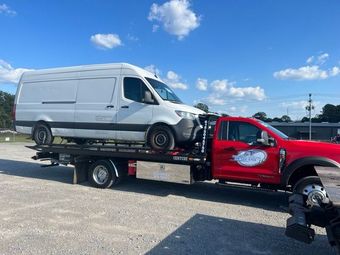 Flatbed Tow truck from E & E Towing Service transporting a commercial truck in Clarksville, TN
