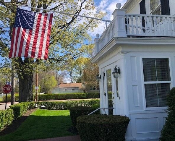 White house with an American flag hanging outside on a sunny day