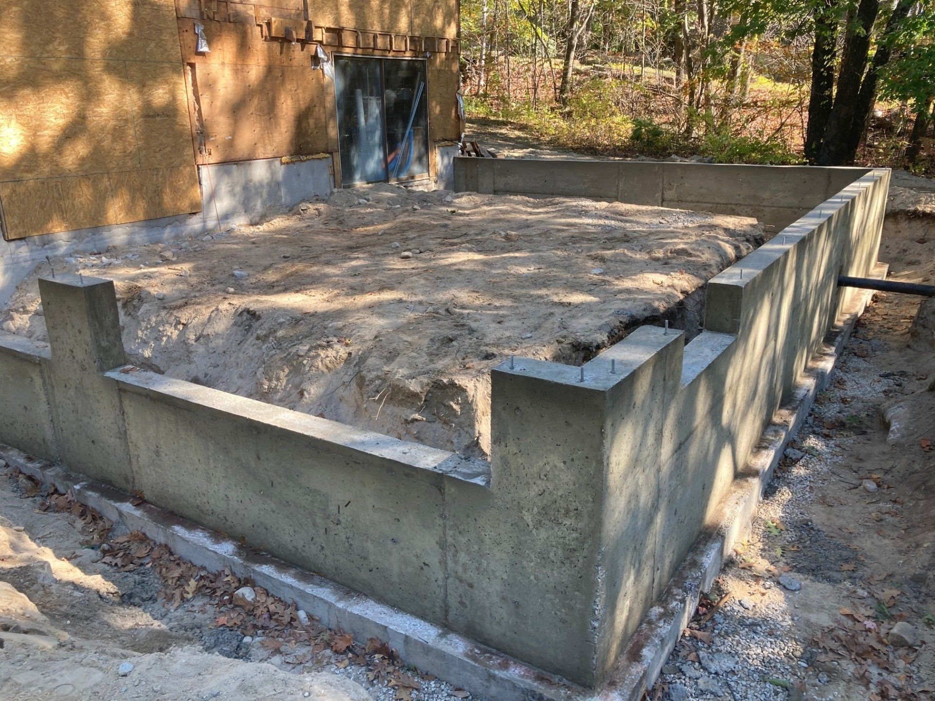 A concrete wall is being built in front of a house.