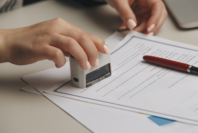 A person is stamping a piece of paper with a stamp.