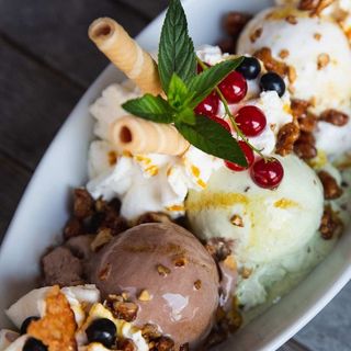 ein weißer Teller mit verschiedenen Eiskugeln und Früchten