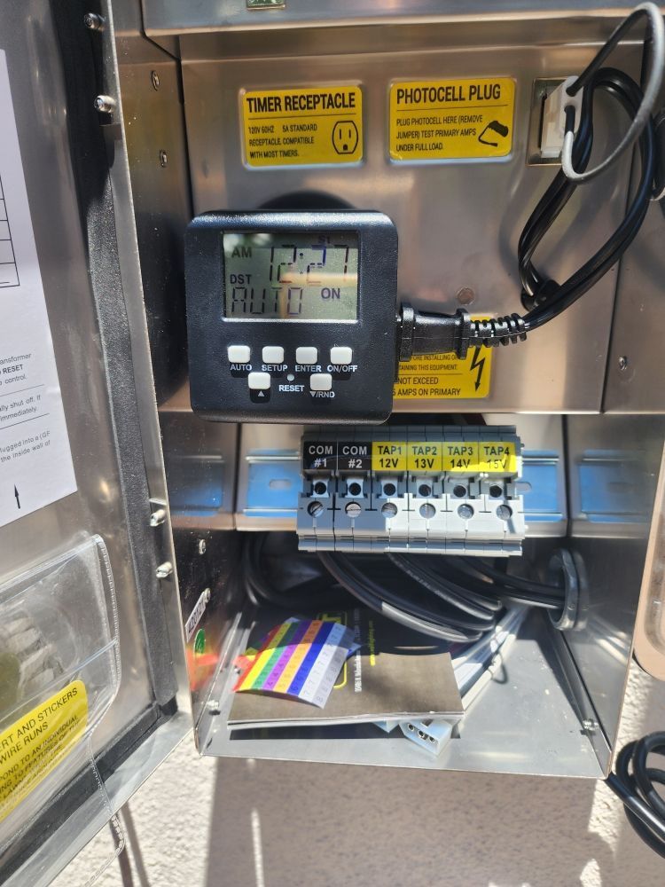 Inside electrical control panel with display, wiring, breaker switches, and warning labels.