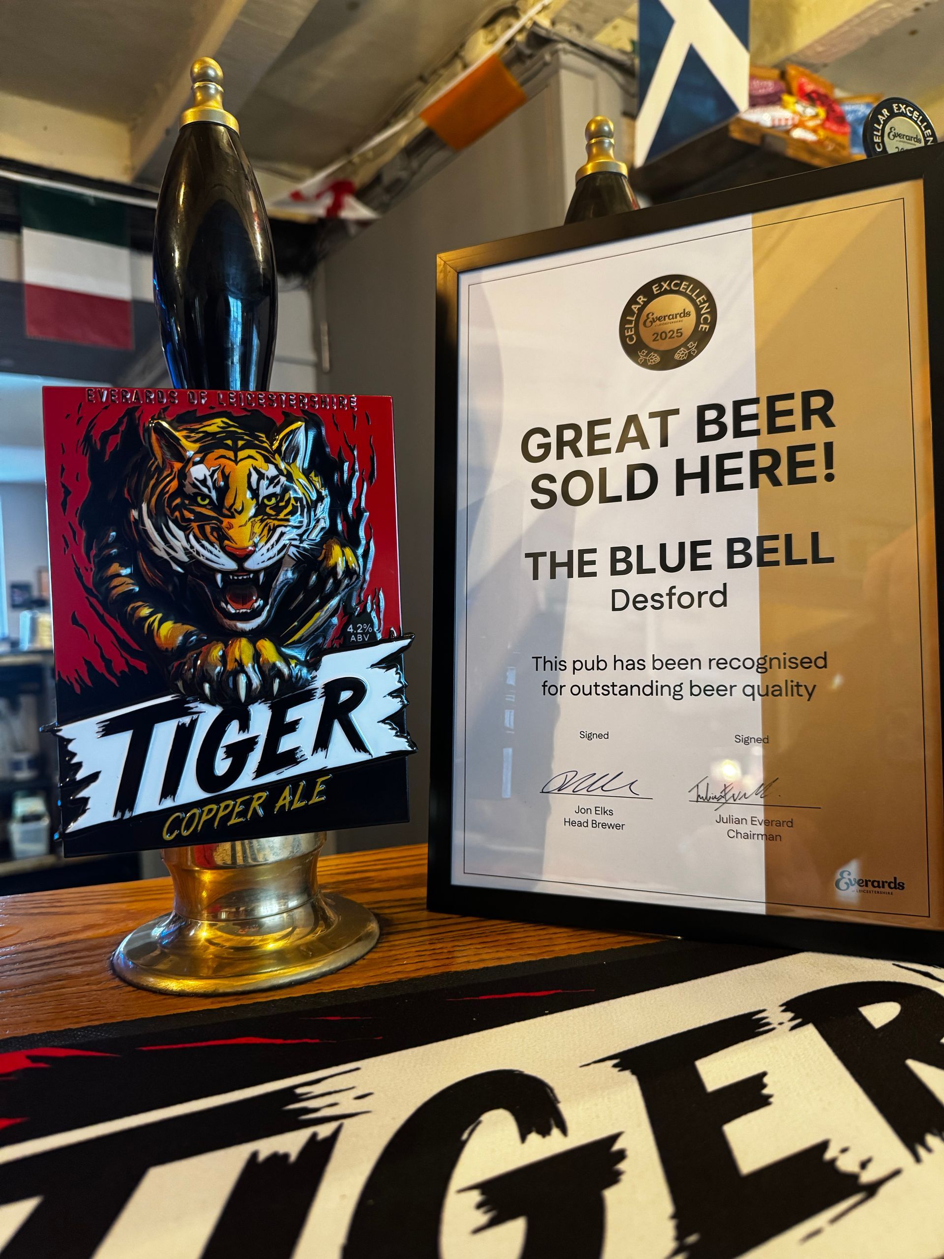 Tiger beer sign and Great Bear sculpture award display in a bar setting