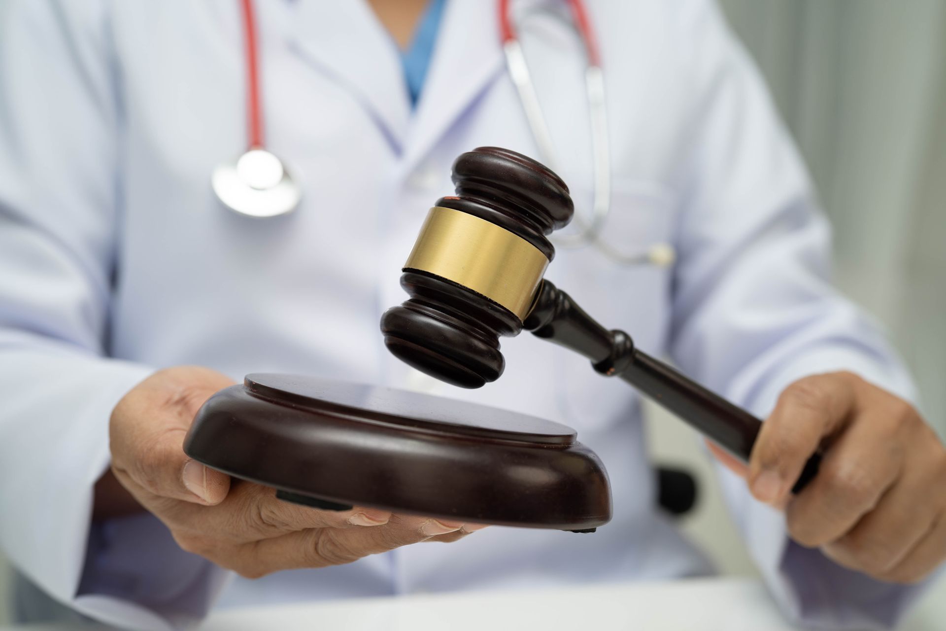 Doctor in white coat holds a gavel, medical malpractice claims in Texas.