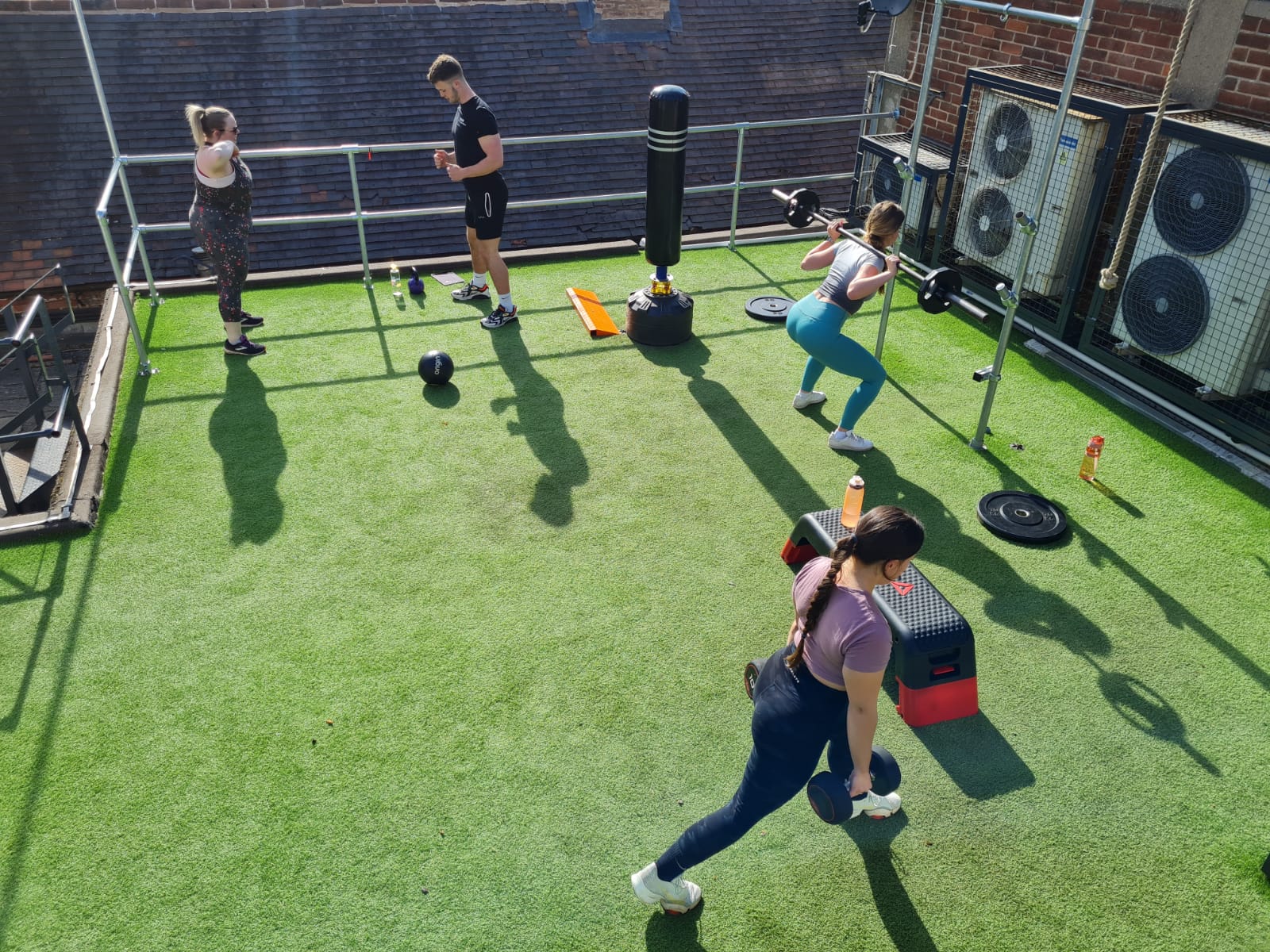 A group of people are doing exercises on a rooftop.