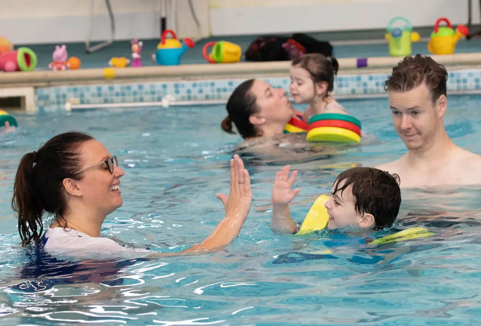 A group of people are playing in a swimming pool.