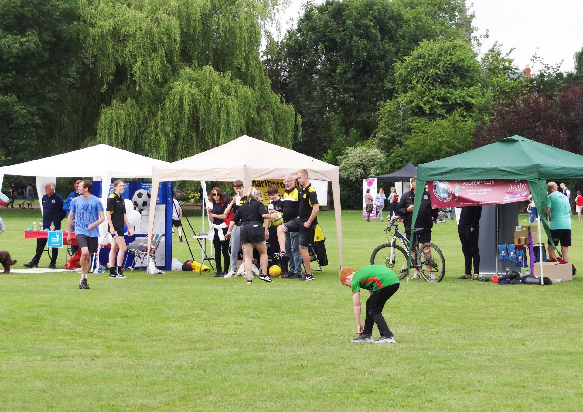 A group of people are standing in a field with tents.