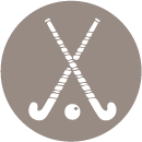 A pair of crossed field hockey sticks and a ball in a circle.