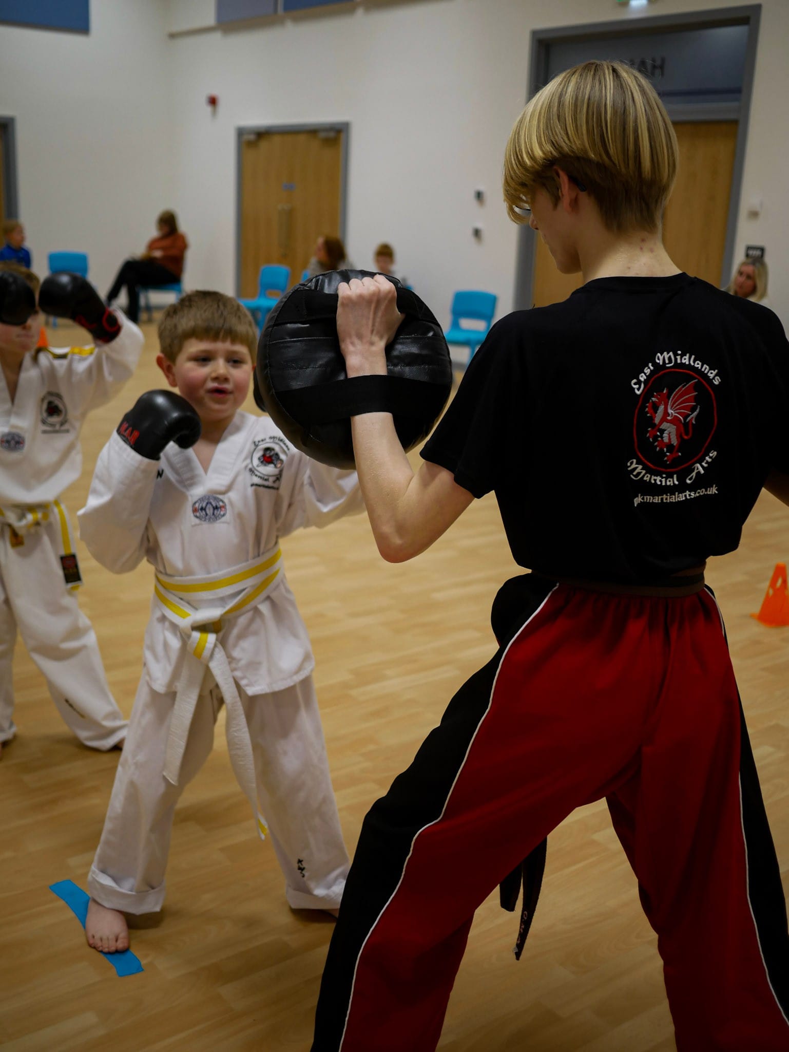 A group of young boys are practicing martial arts in a gym.