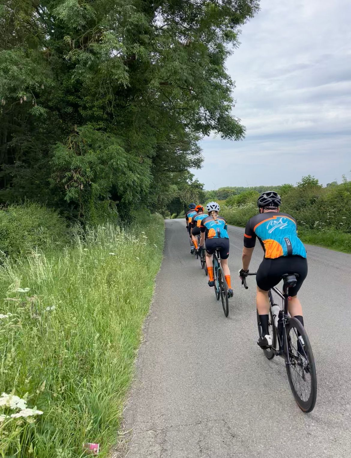 A group of people are riding bicycles down a road.