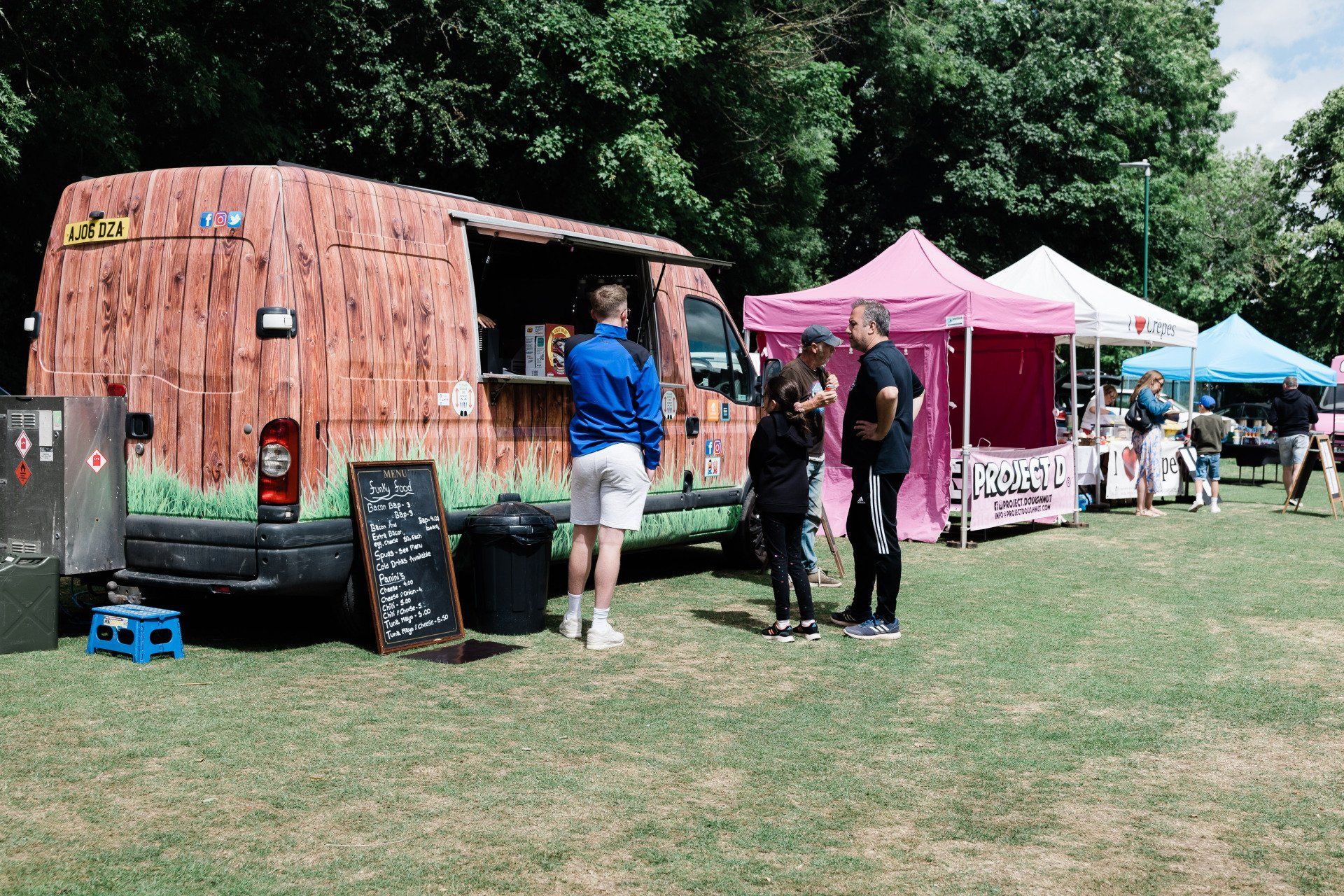 A group of people are standing in front of a food truck.