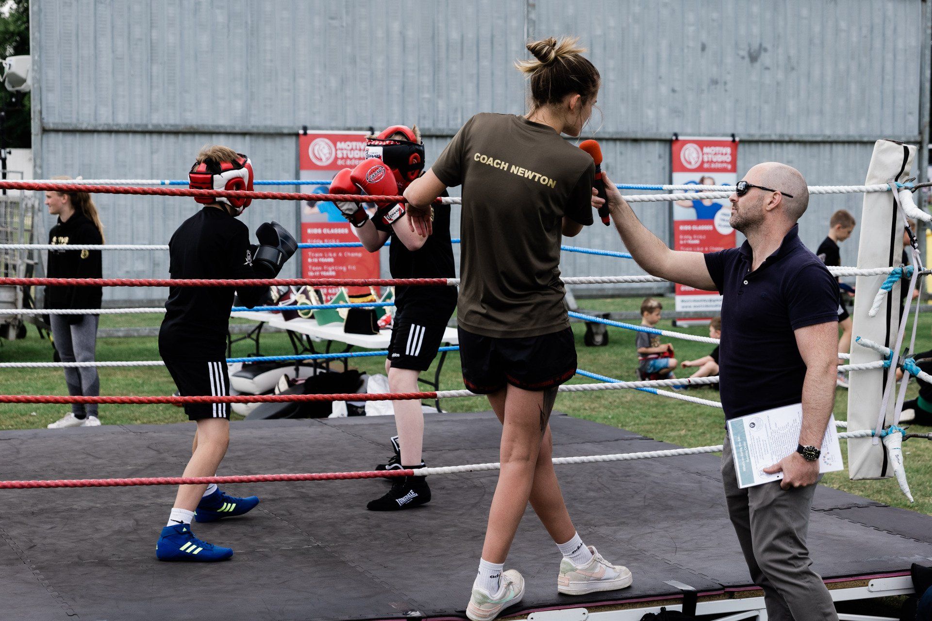 A man is standing next to a woman in a boxing ring.