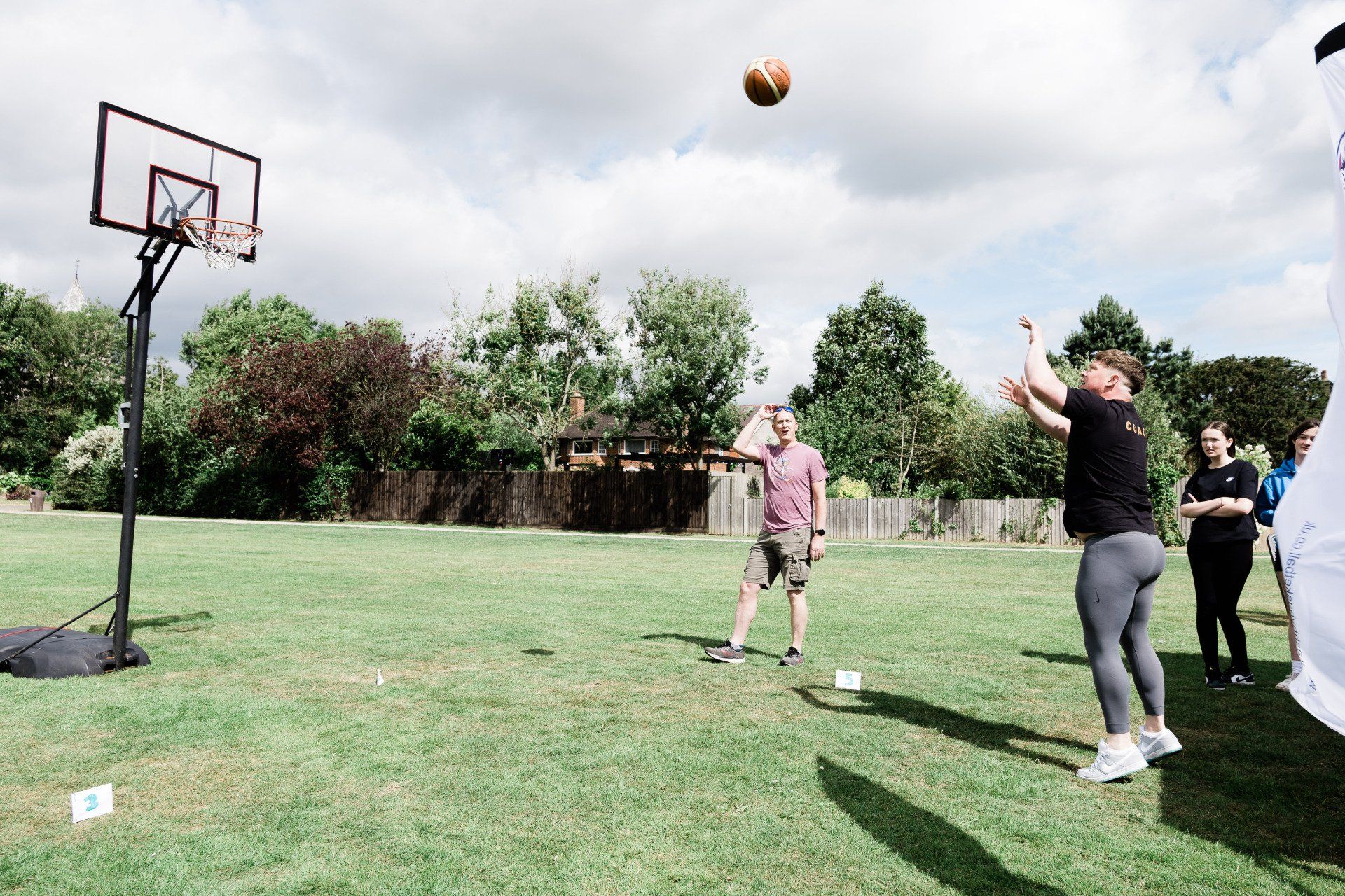A group of people are playing basketball in a park.