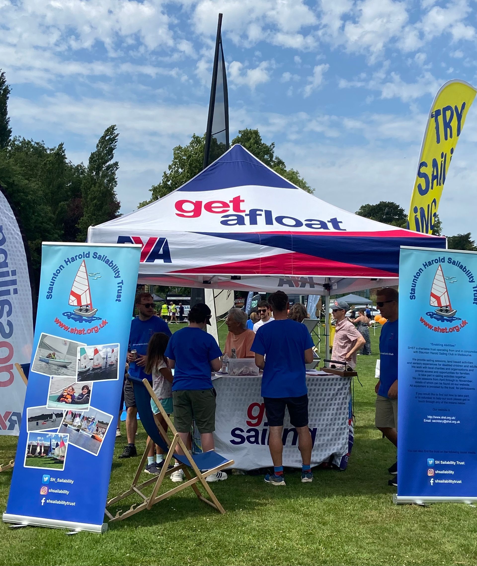 A group of people standing under a tent that says get afloat
