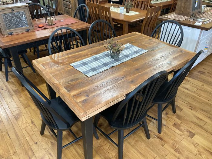 A wooden table and chairs are sitting on a wooden floor in a room.