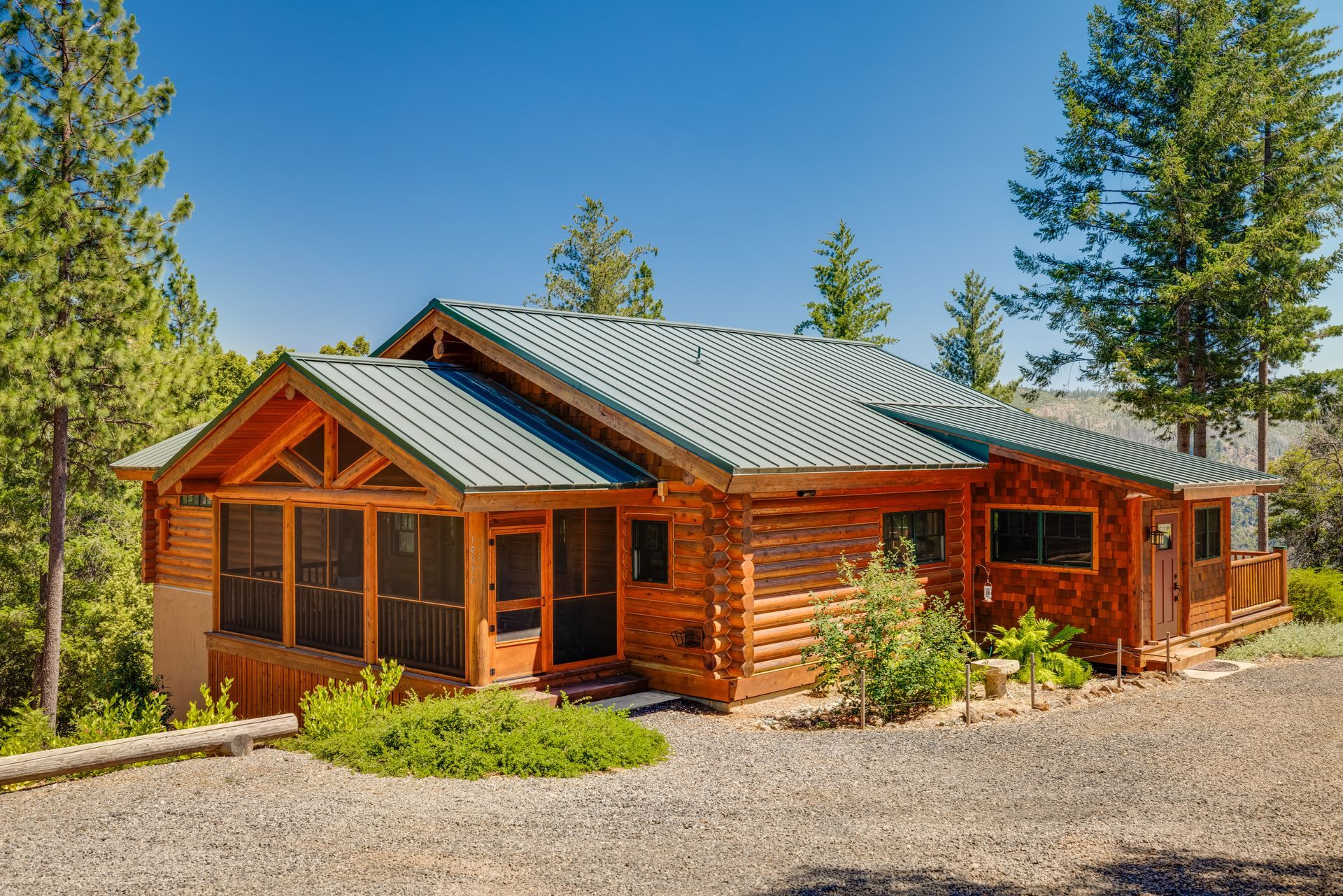 Log-style home surrounded by trees and lawn