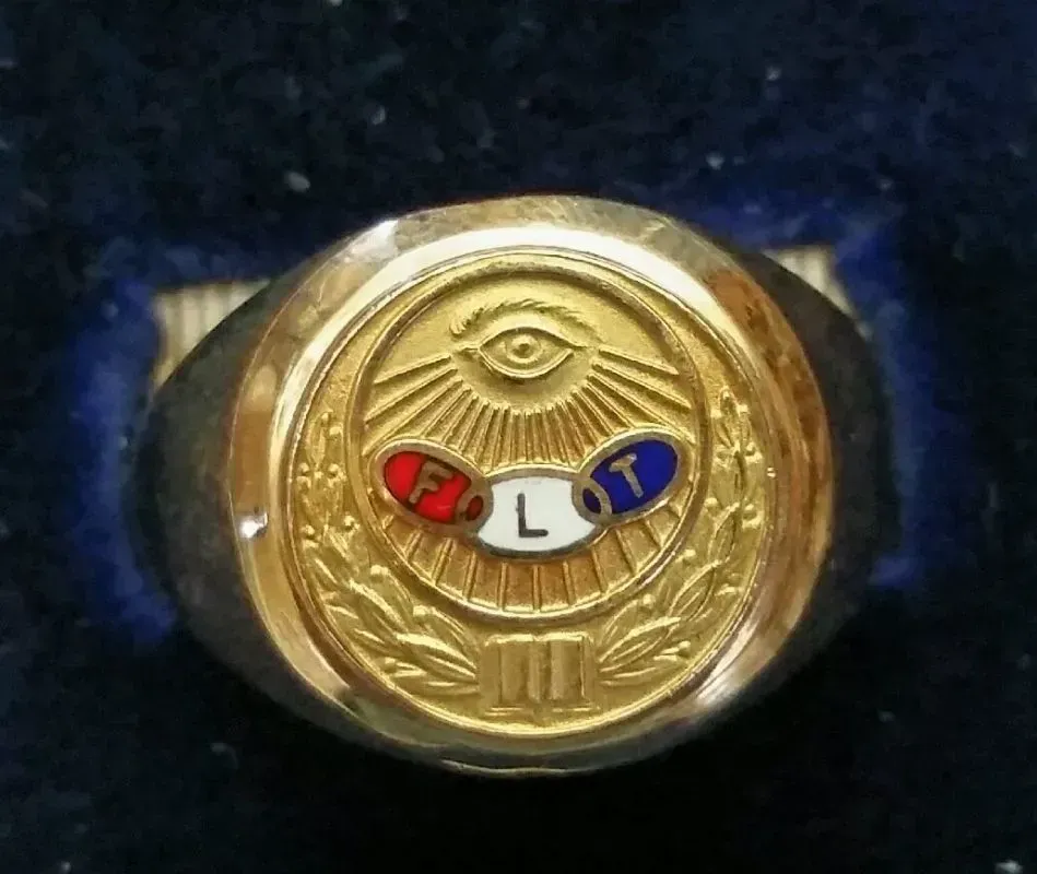 A gold ring with the letter l on it
