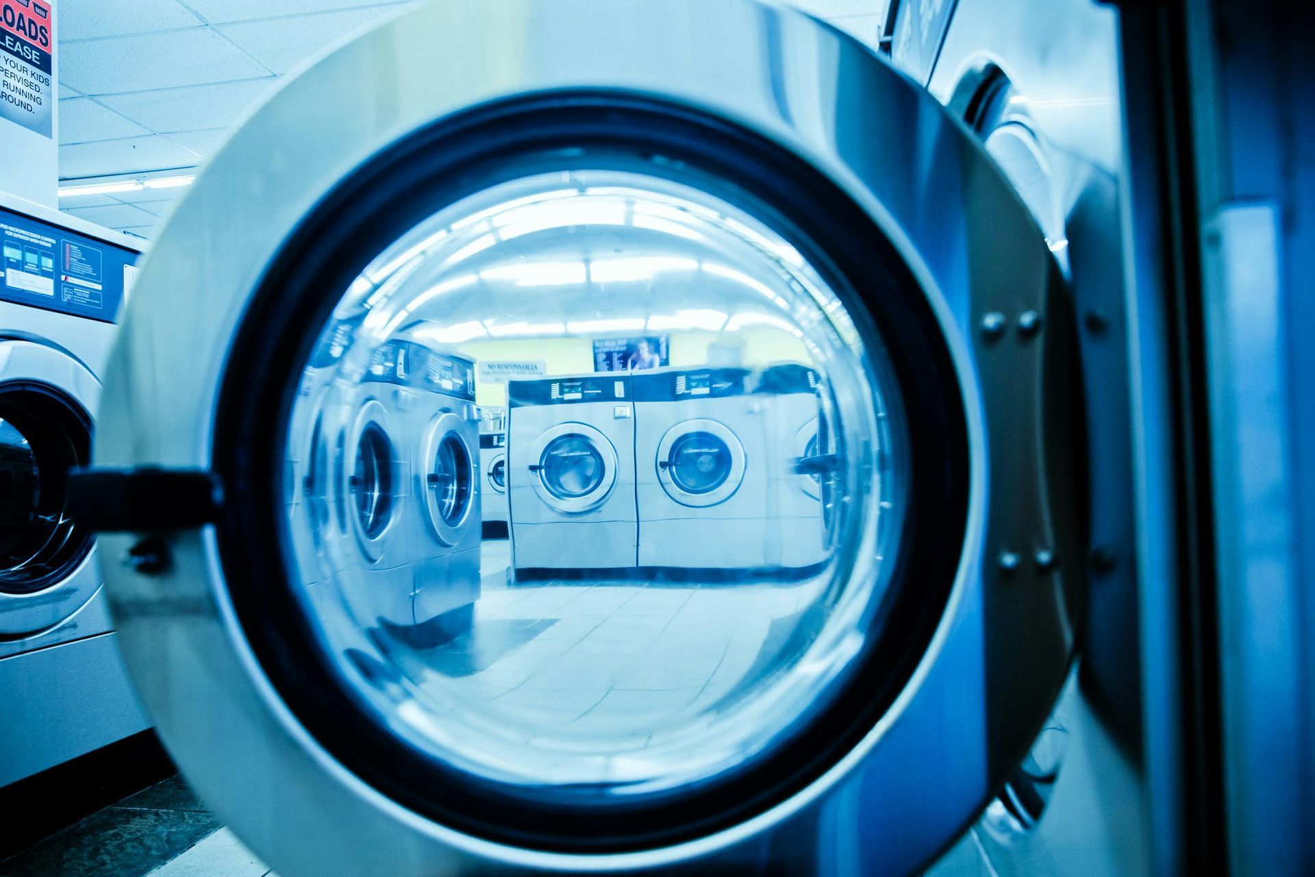 A row of washing machines are lined up in a laundromat.