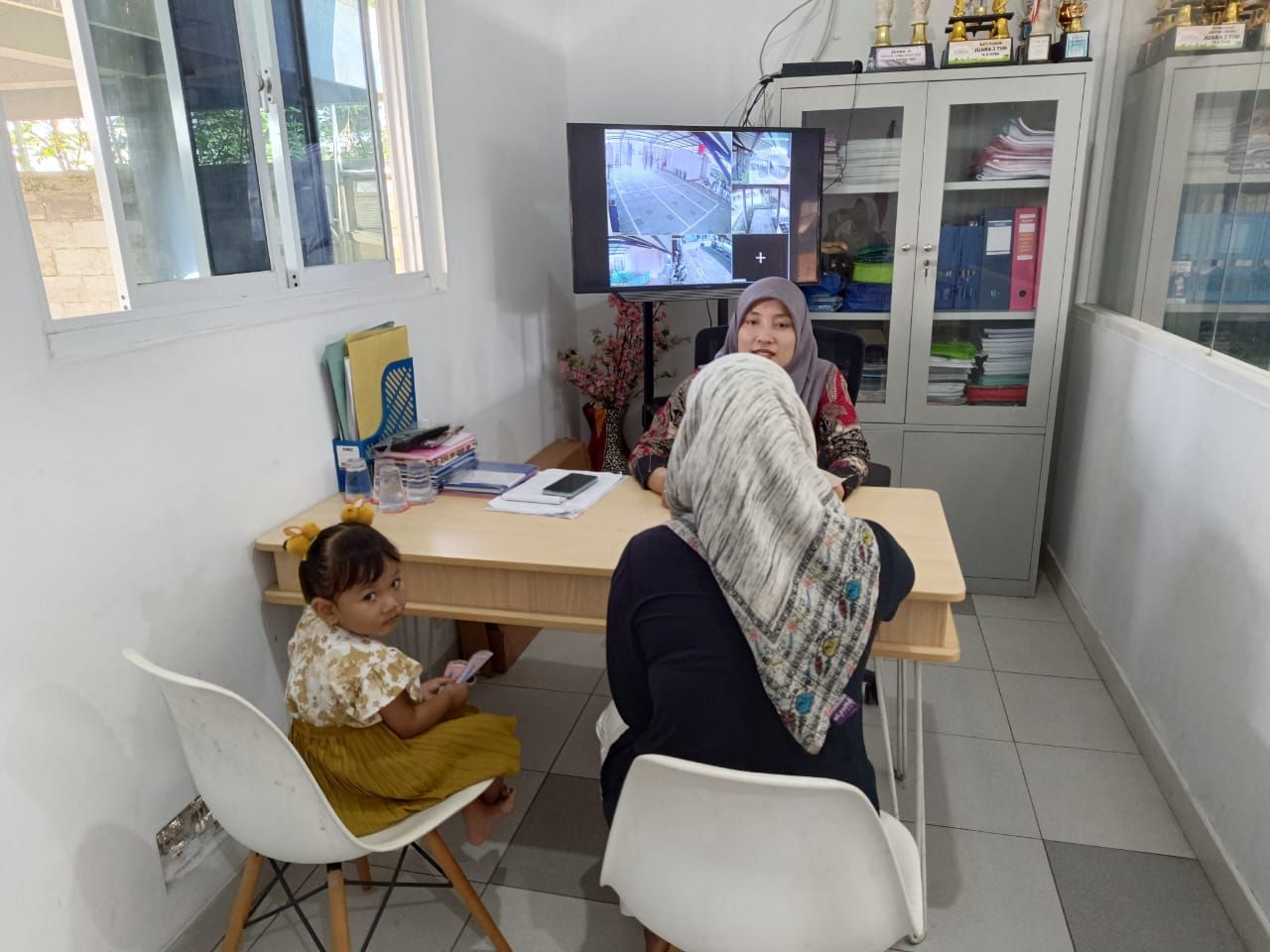 A woman and a child are sitting at a table in a room.