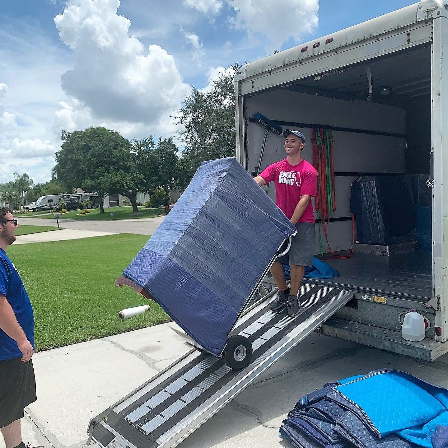 Eagle Moving crew loading a wrapped item into a truck