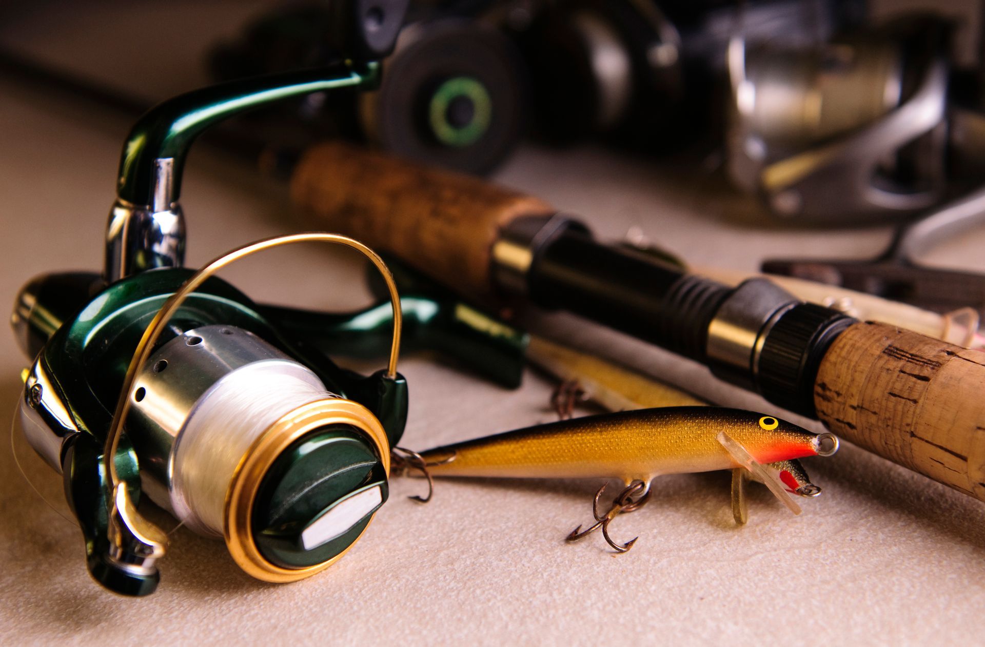 A fishing rod , reel , and lure are on a table.