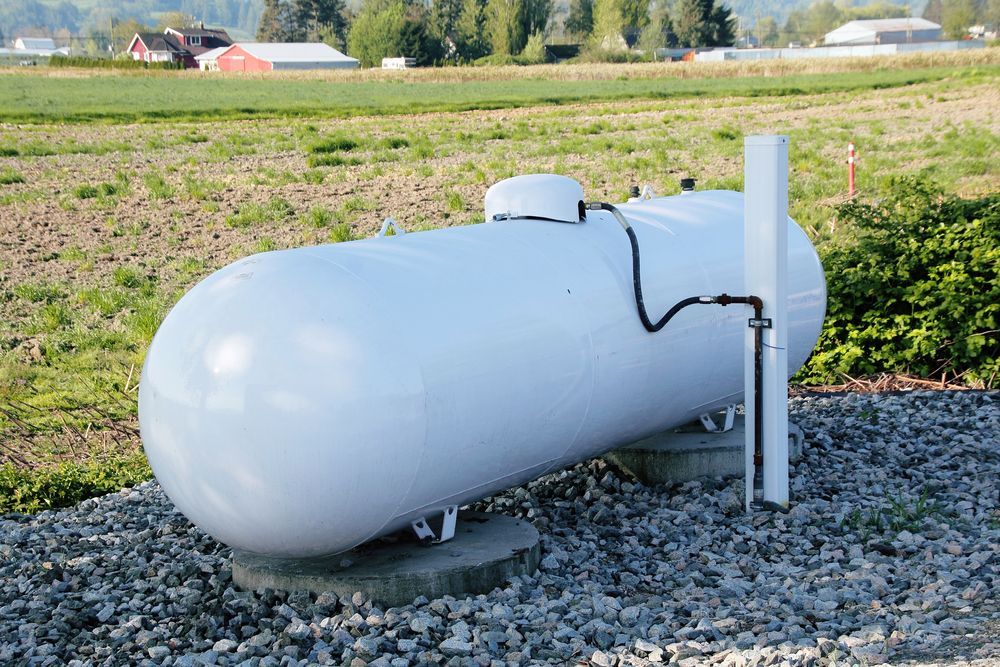 A large white propane tank is sitting in the middle of a field in Southern MD.