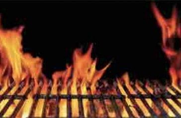 A close up of a grill with flames coming out of it.