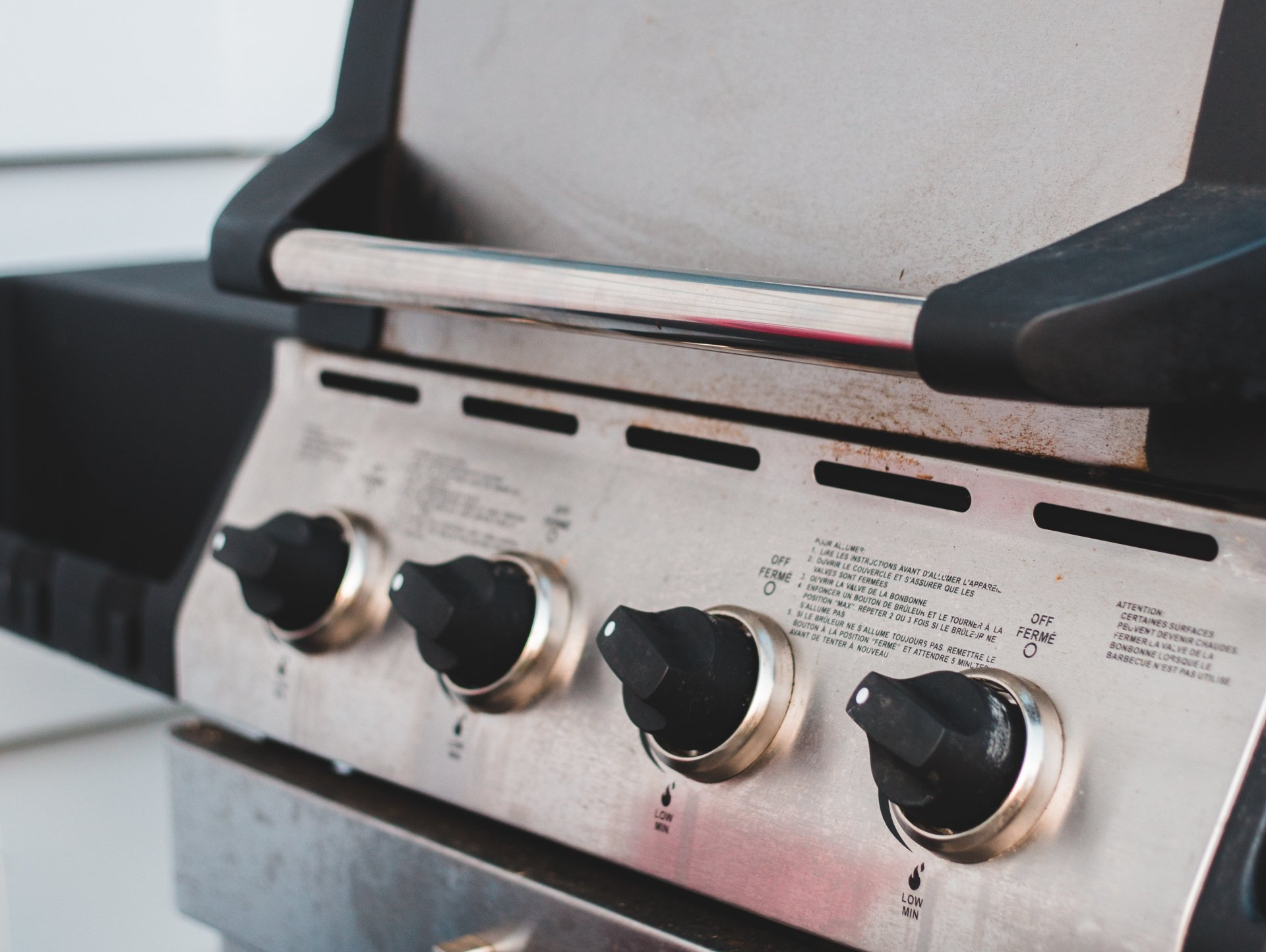 A close up of a gas grill with the lid open