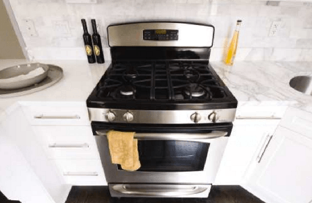 A stainless steel stove and oven are in a kitchen.