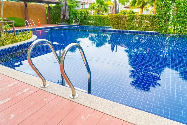 A large swimming pool with stairs leading to clean pool water.