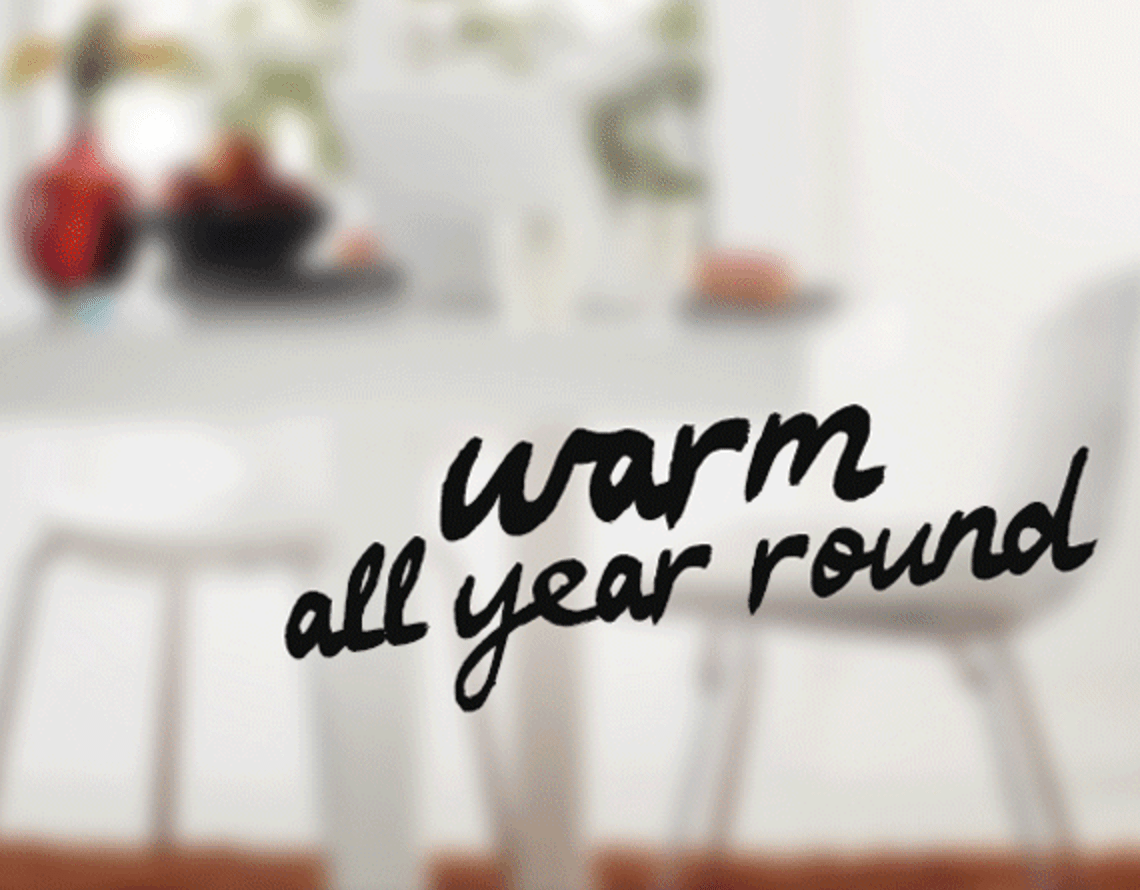 A sign on a wall that says warm all year round