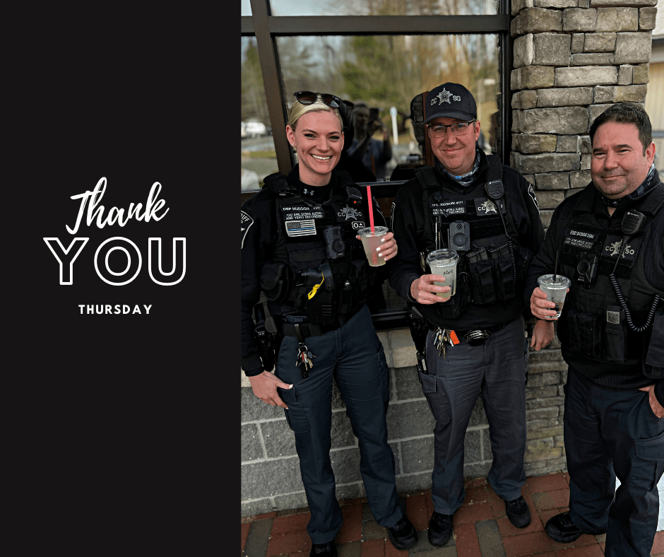 A group of police officers standing next to each other holding drinks.
