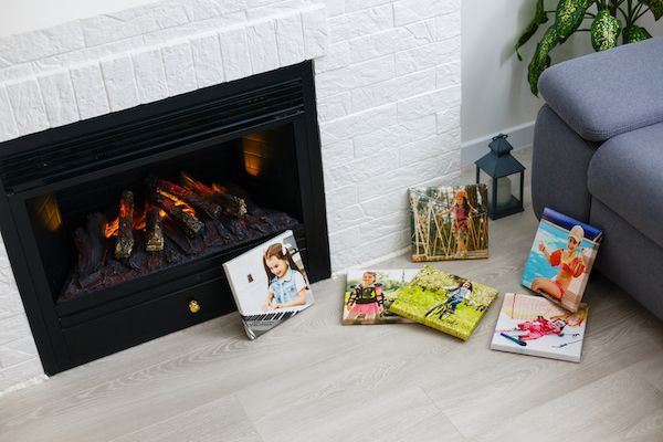 A gas fireplace in lusby md with a lot of pictures on the floor in front of it.