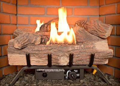 a propane fueled fire place with a fire surrounded by logs.