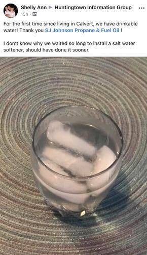 A glass of water with ice cubes in it on a table.