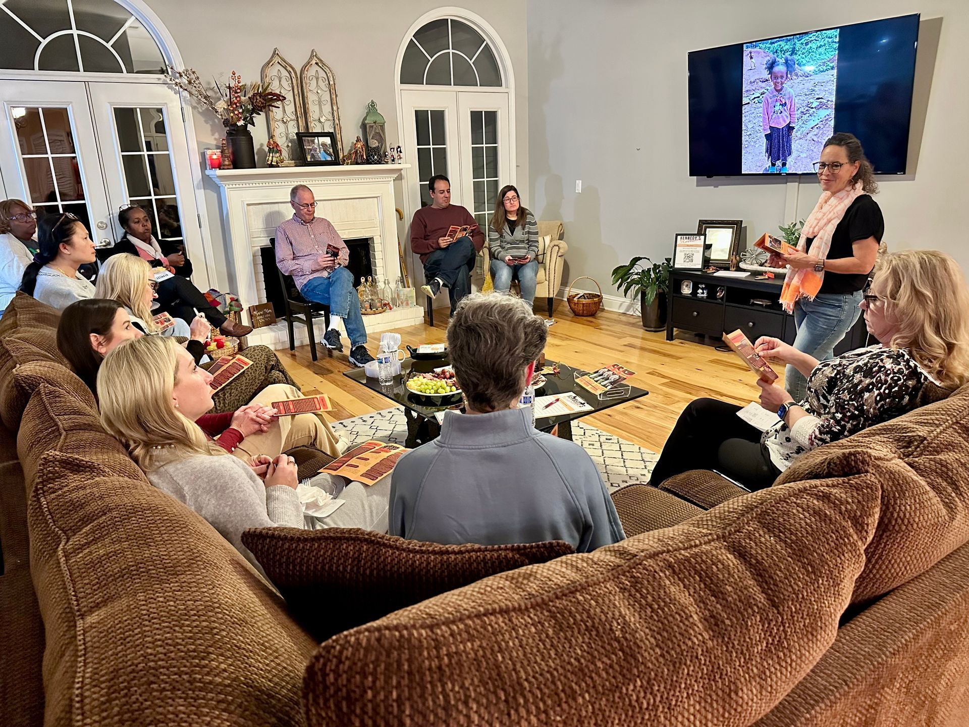 Small group in a circle during a counseling session in a cozy room with a cross on the wall and warm lighting.